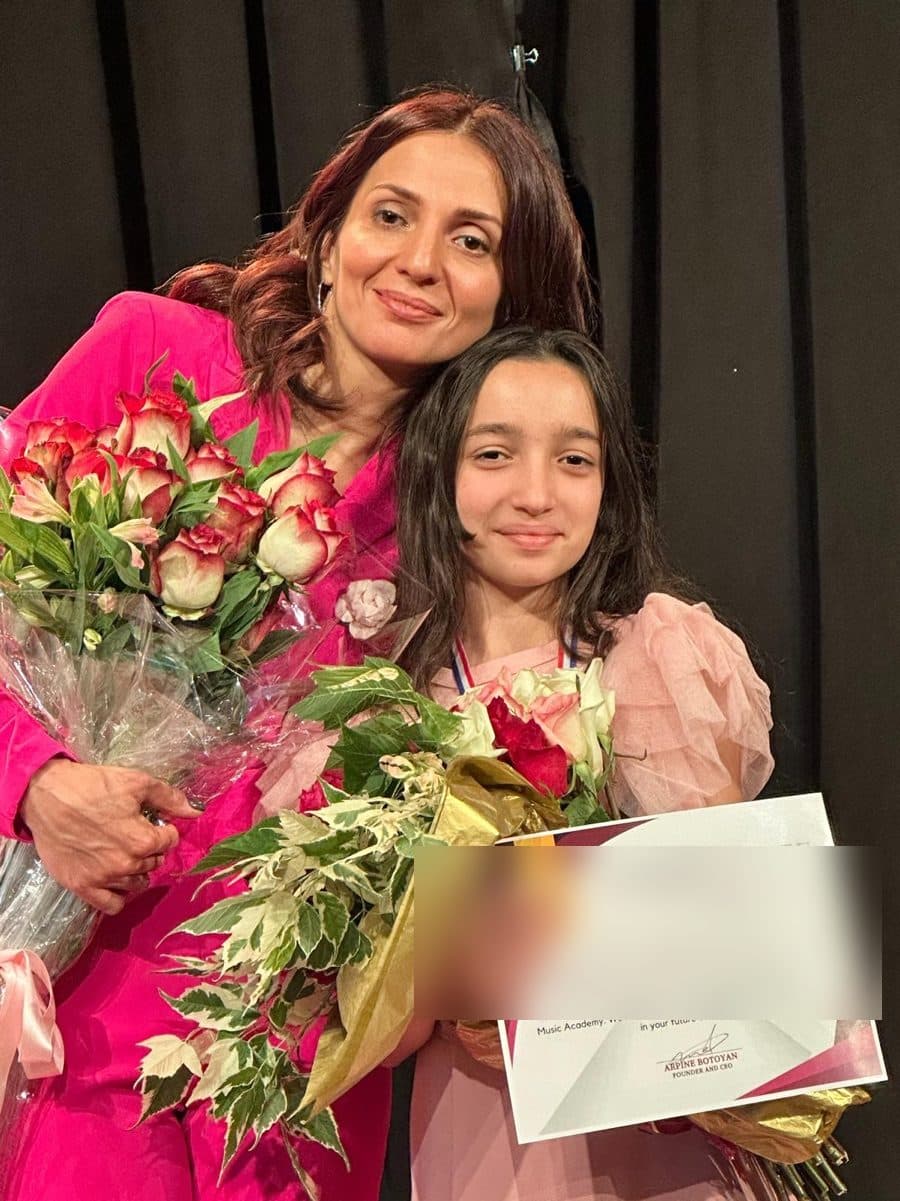 A student honored with roses and a certificate of completion at ABA Music Academy's 2026 end-of-year concert
