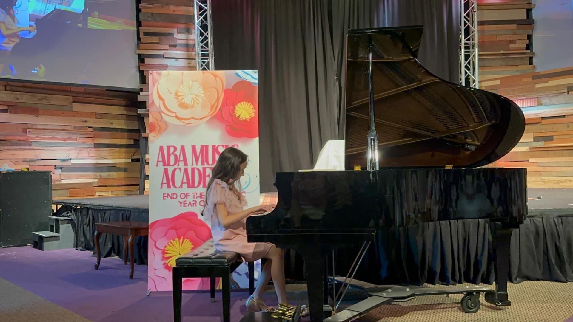 A student performing at the grand piano during ABA Music Academy's 2026 end-of-year concert