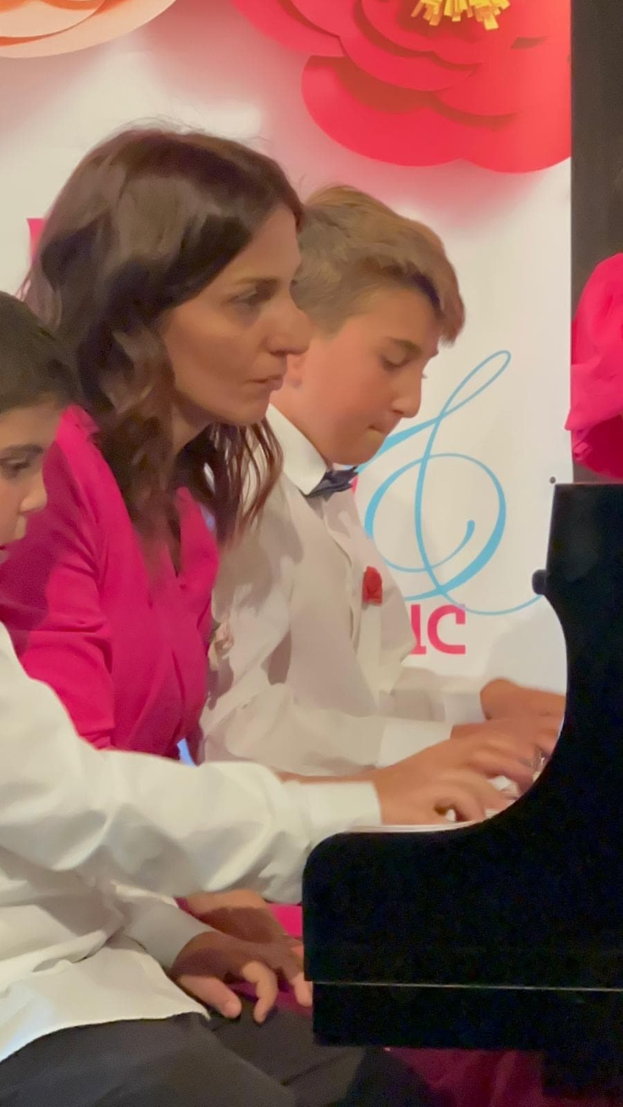 Arpine playing a duet with a student, four hands at one piano