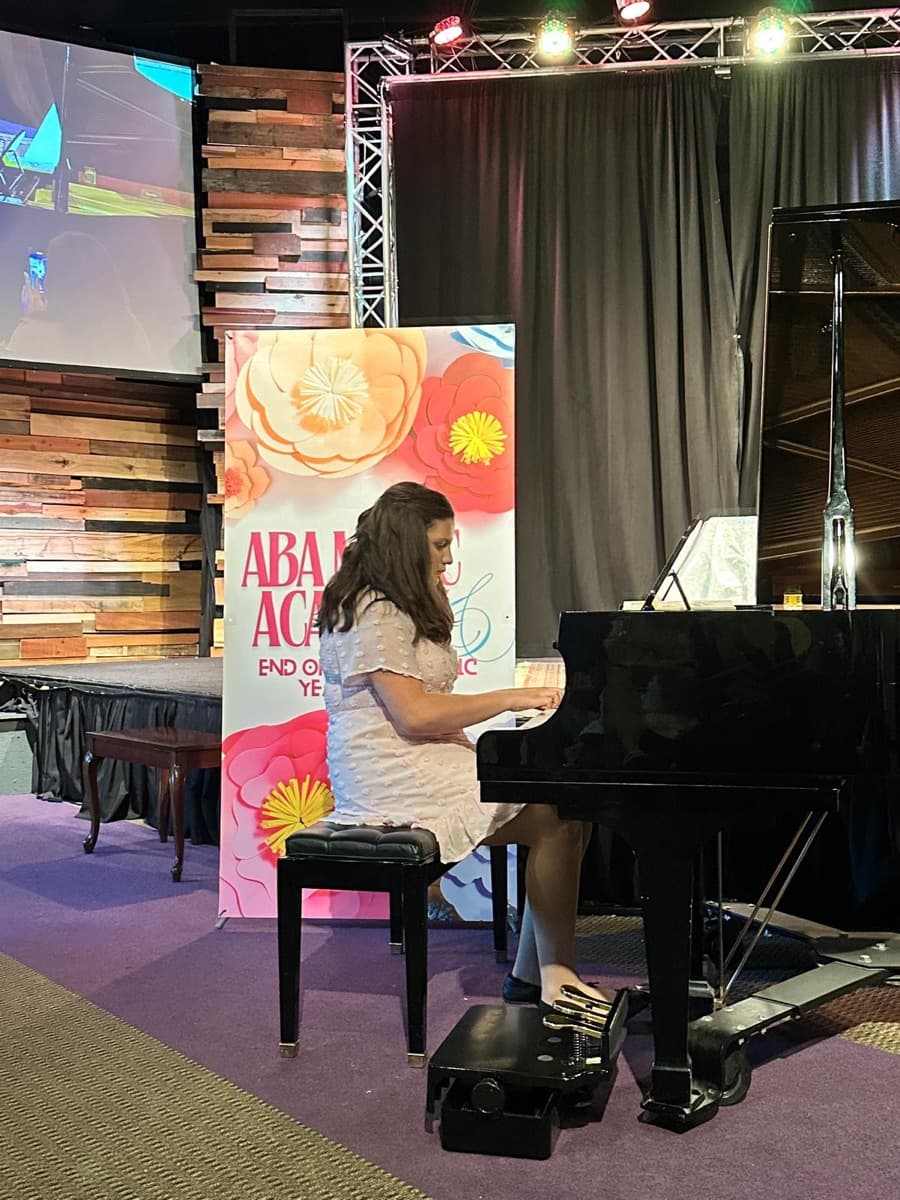 A teen student performing at the grand piano at the June 2026 concert
