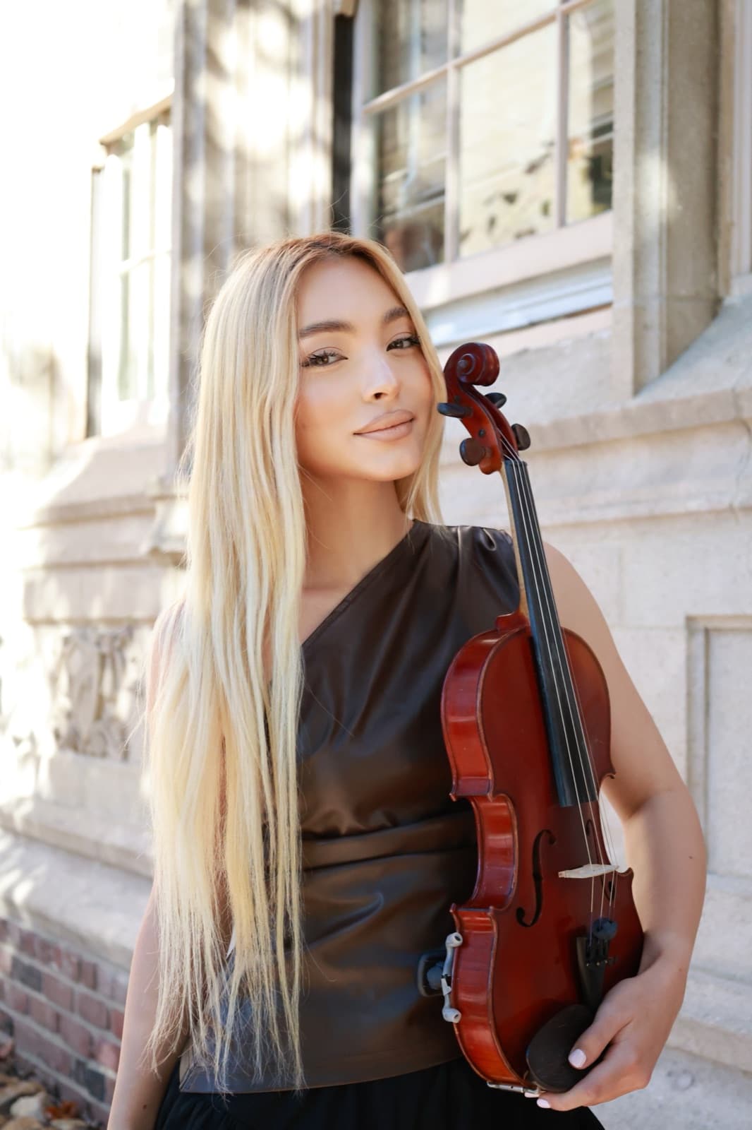 Asya Anisimova, violin teacher at ABA Music Academy, holding her violin